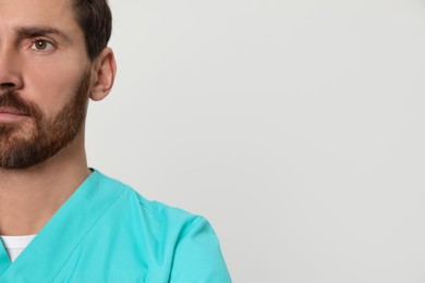 Nurse in medical uniform on white background, closeup. Space for text