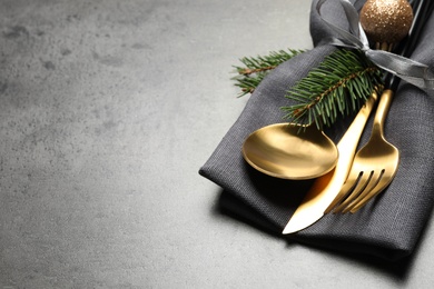 Photo of Cutlery set and Christmas decor on grey table, closeup. Space for text