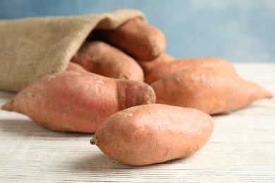 Photo of Ripe sweet potatoes on white wooden table