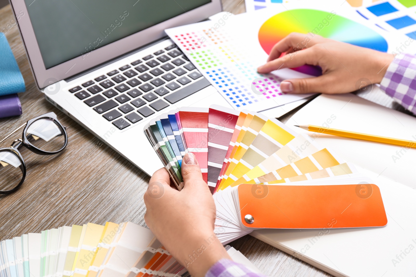 Photo of Woman with palette samples at wooden table, closeup