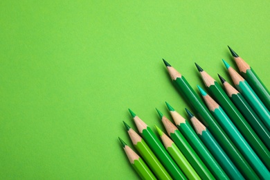 Photo of Flat lay composition with color pencils on green background. Space for text