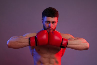 Man in boxing gloves on color background