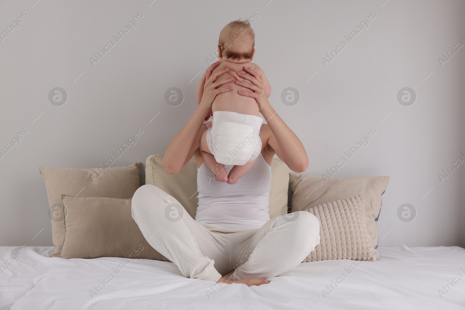 Photo of Mother with her newborn baby on bed at home