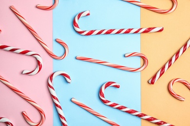 Photo of Flat lay composition with tasty candy canes on color background