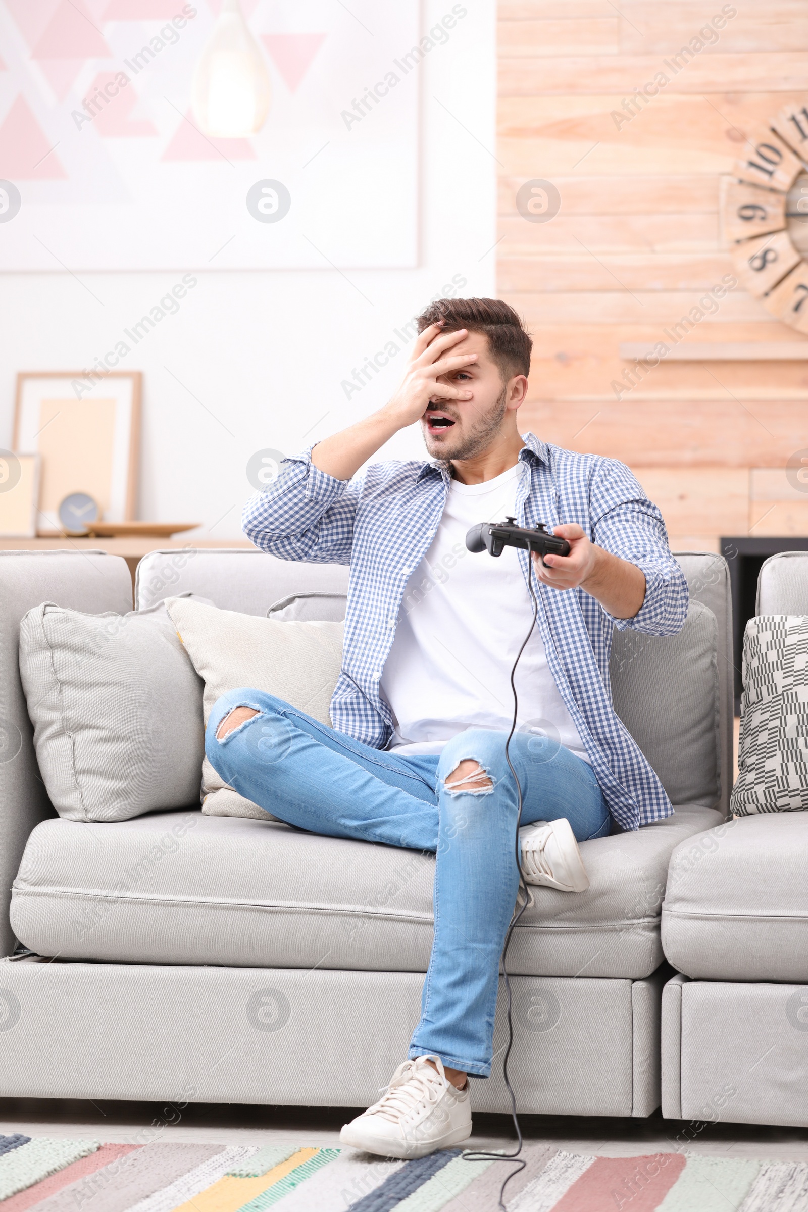 Photo of Emotional young man playing video games at home