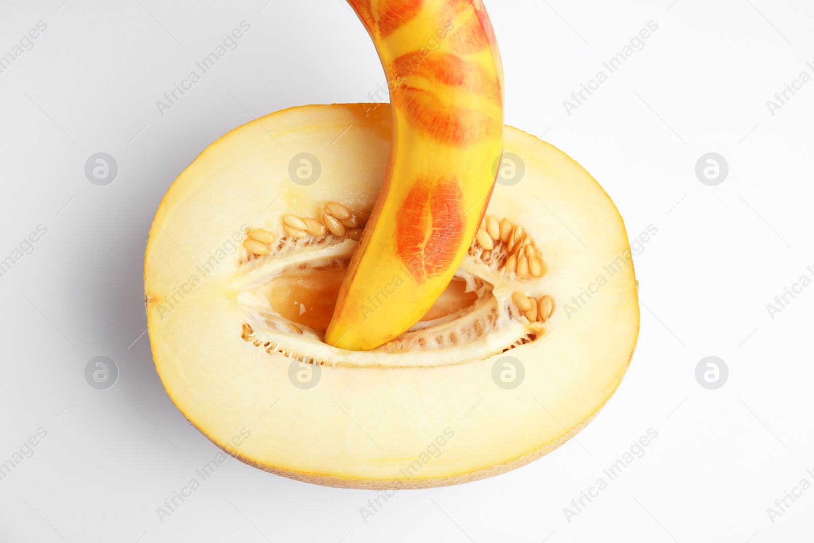 Photo of Fresh melon and banana with red lipstick marks on white background, top view. Sex concept
