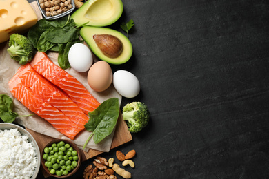 Photo of Products rich in protein on black table, flat lay. Space for text