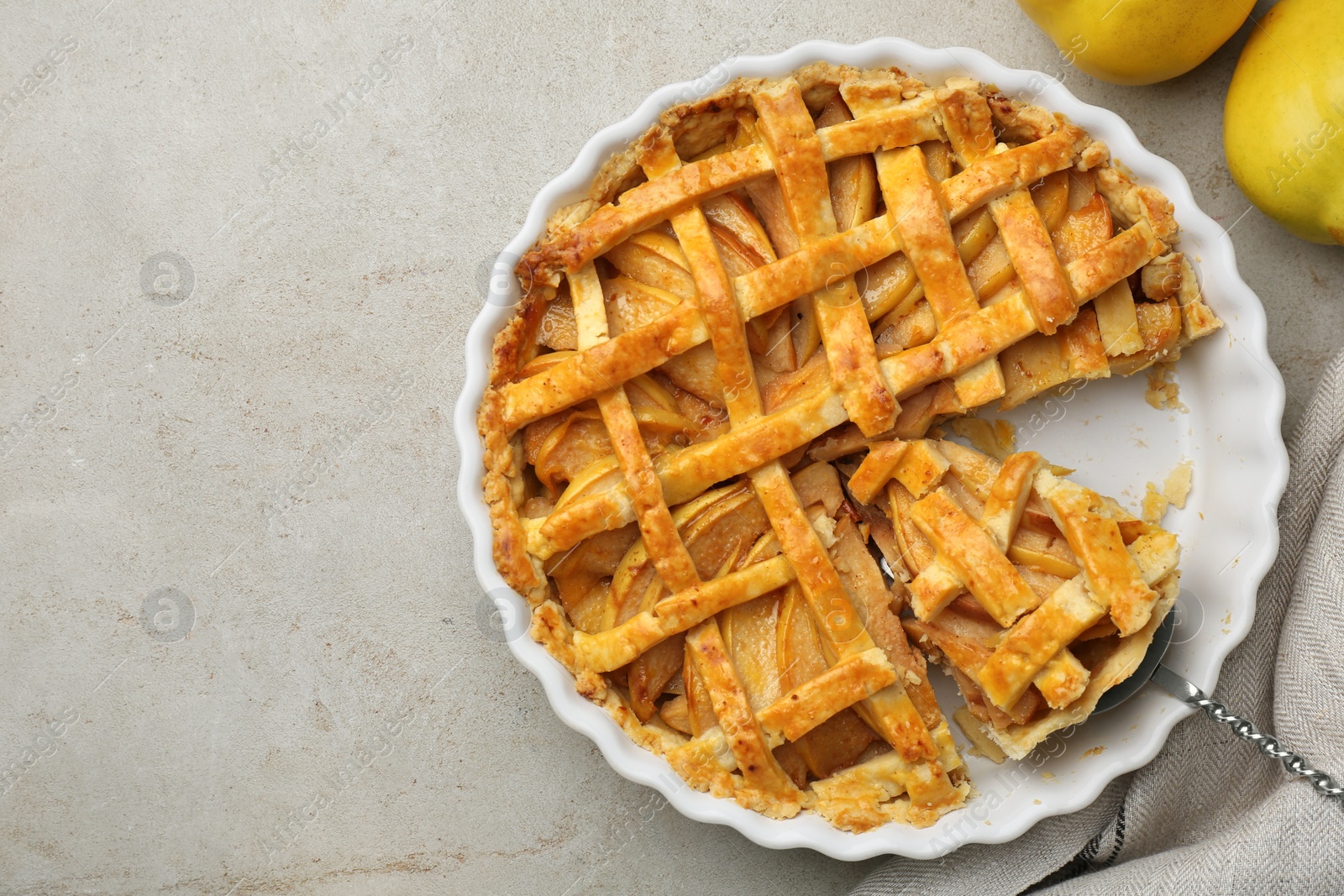 Photo of Tasty homemade quince pie with cake server and fresh fruits on light grey table, flat lay. Space for text