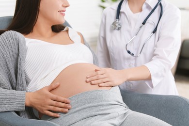 Photo of Doctor examining pregnant woman in clinic, closeup