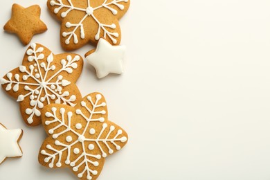 Tasty Christmas cookies with icing on white background, flat lay. Space for text