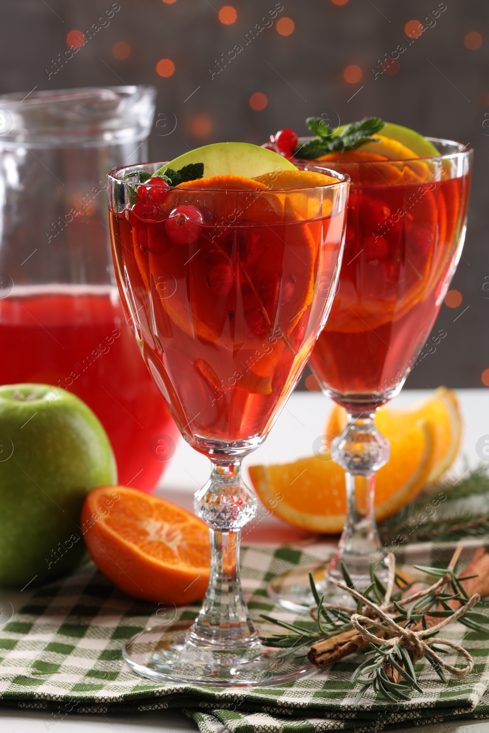 Photo of Christmas Sangria cocktail in glasses and ingredients on table