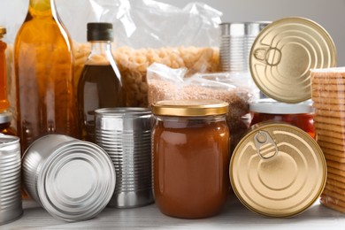 Different products on white wooden table, closeup. Food donation