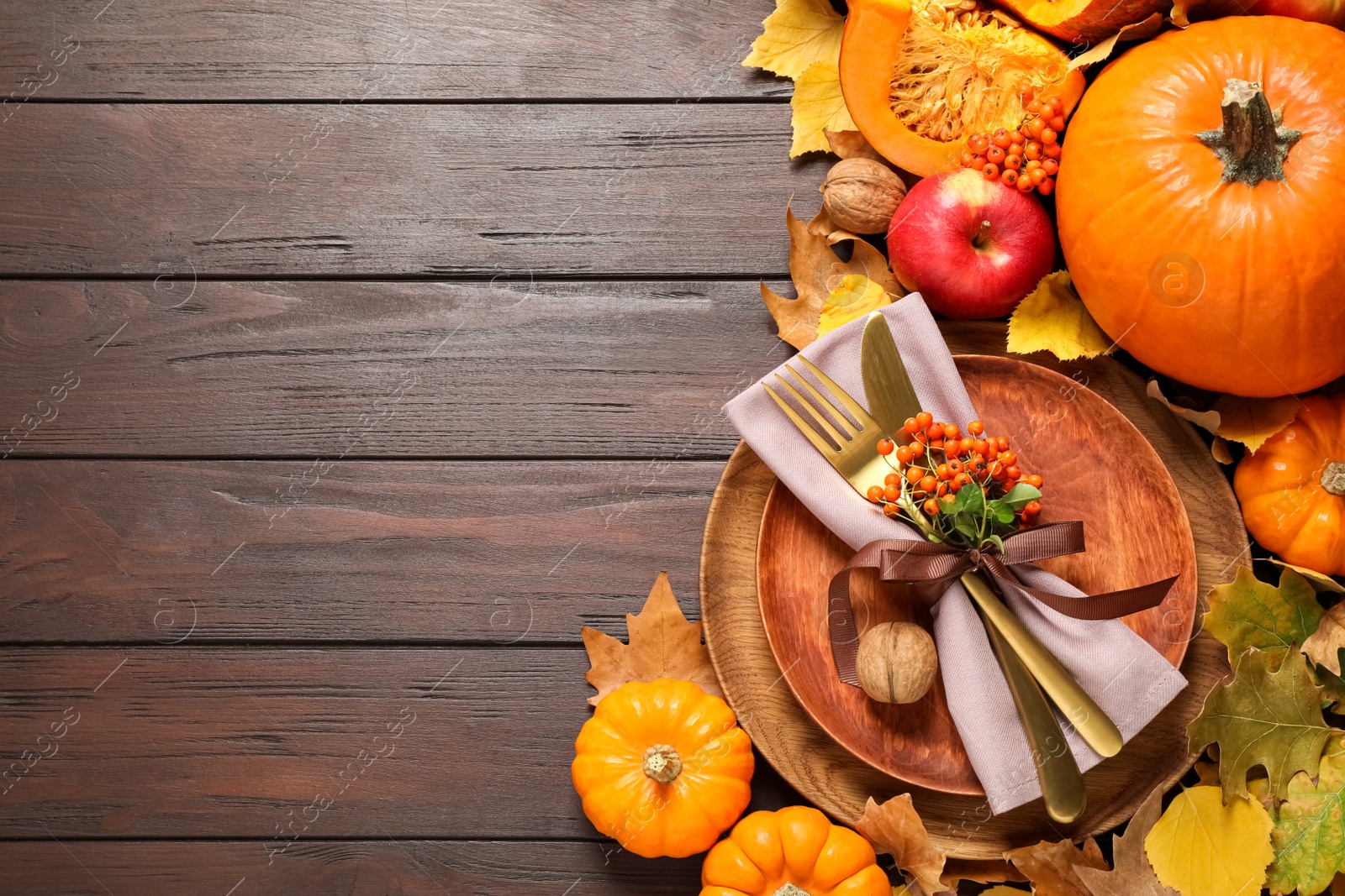 Photo of Flat lay composition with table setting, vegetables and autumn leaves on wooden background, space for text. Thanksgiving Day