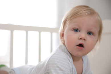 Photo of Adorable little baby on blurred background, closeup