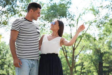 Lovely couple walking together in park on sunny day