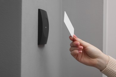 Photo of Woman opening magnetic door lock with key card, closeup. Home security