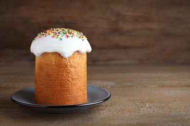 Photo of Traditional decorated Easter cake on wooden table. Space for text