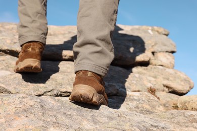 Photo of Tourist climbing on cliff, closeup of legs