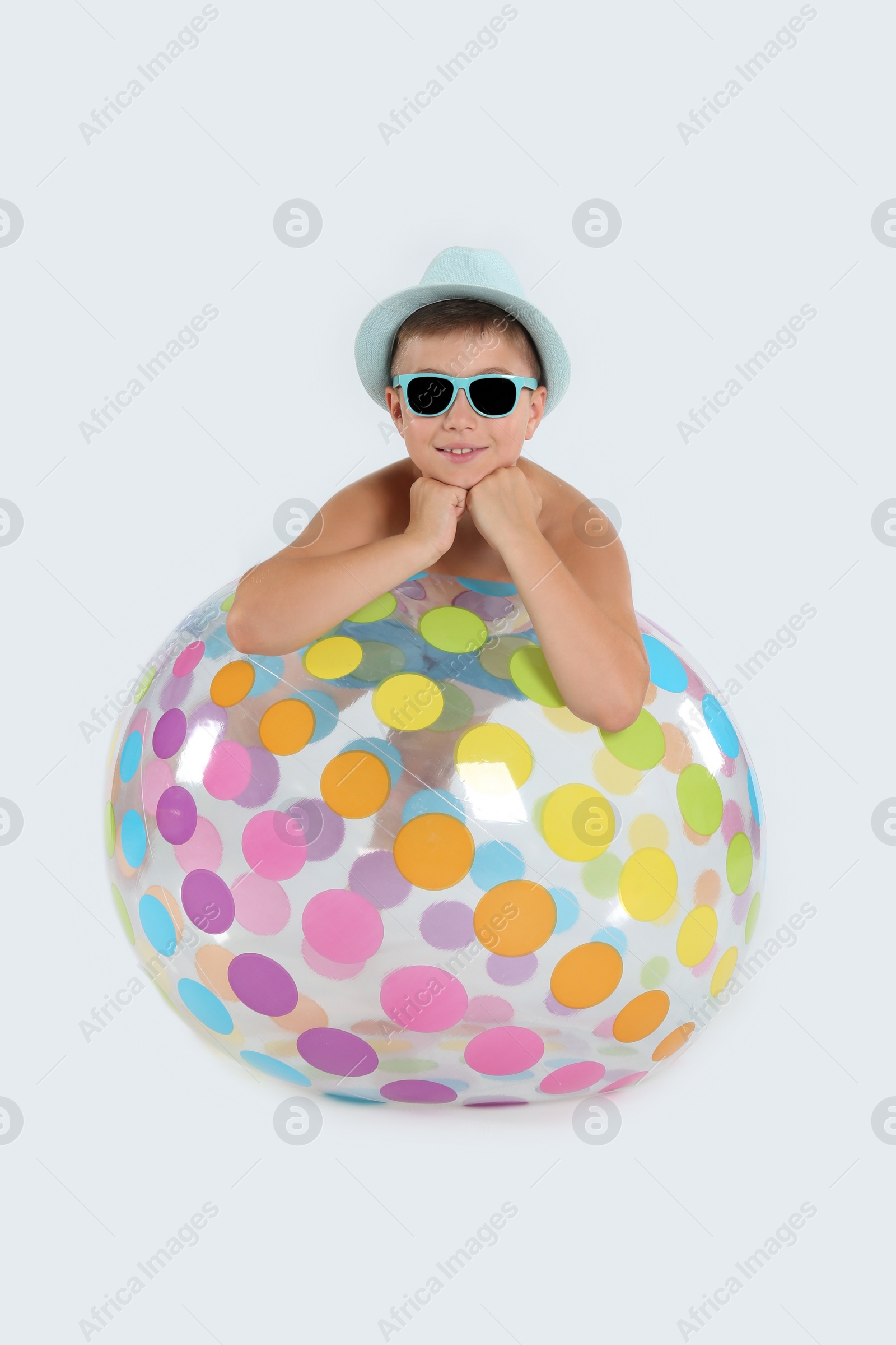 Photo of Cute little child with inflatable ball on white background. Beach holiday