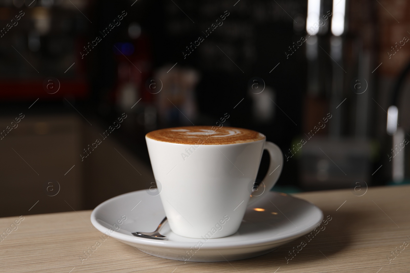 Photo of Cup of aromatic coffee on wooden table in cafe