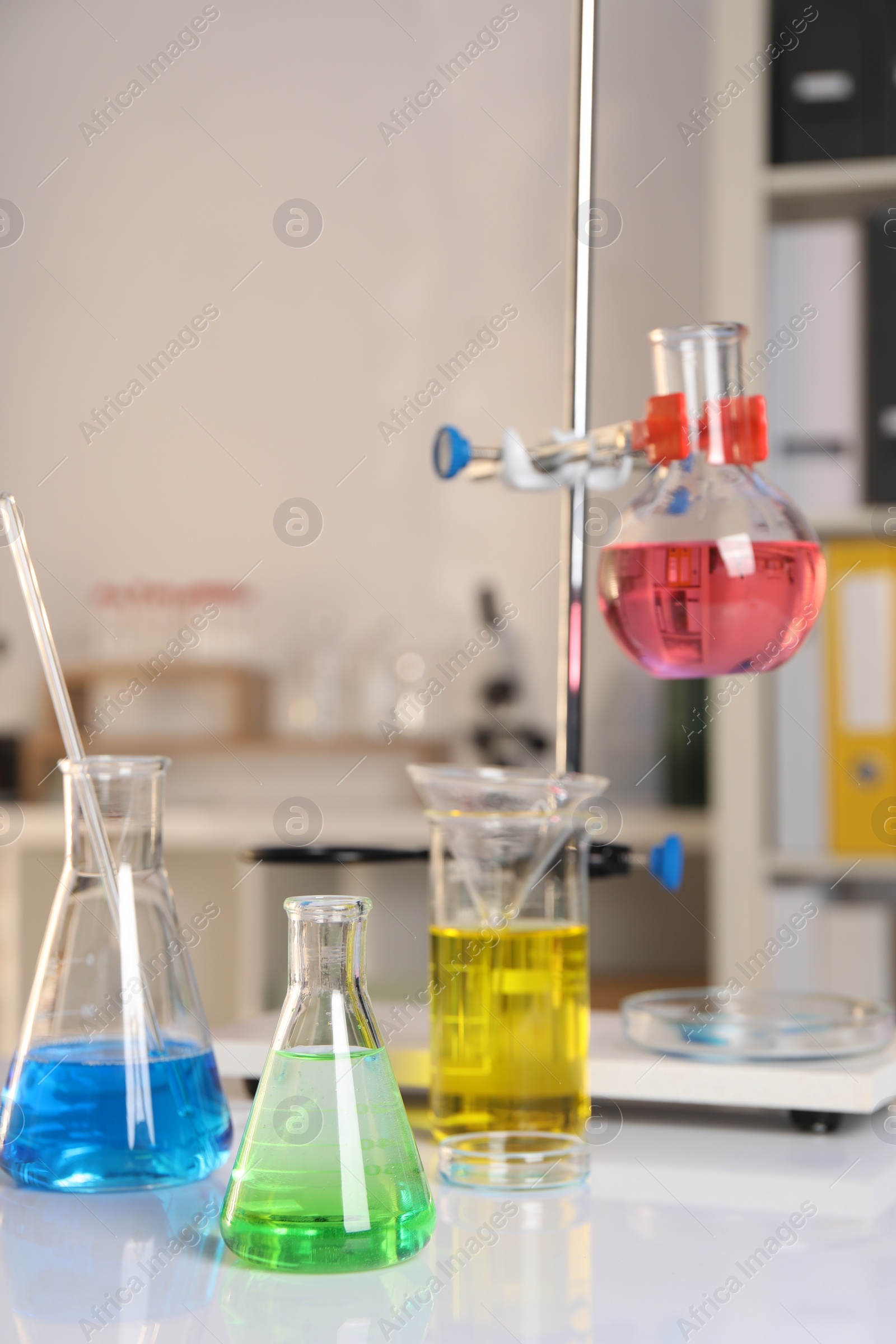 Photo of Laboratory analysis. Glassware with different liquids on white table indoors