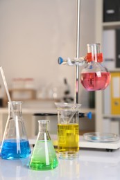 Laboratory analysis. Glassware with different liquids on white table indoors