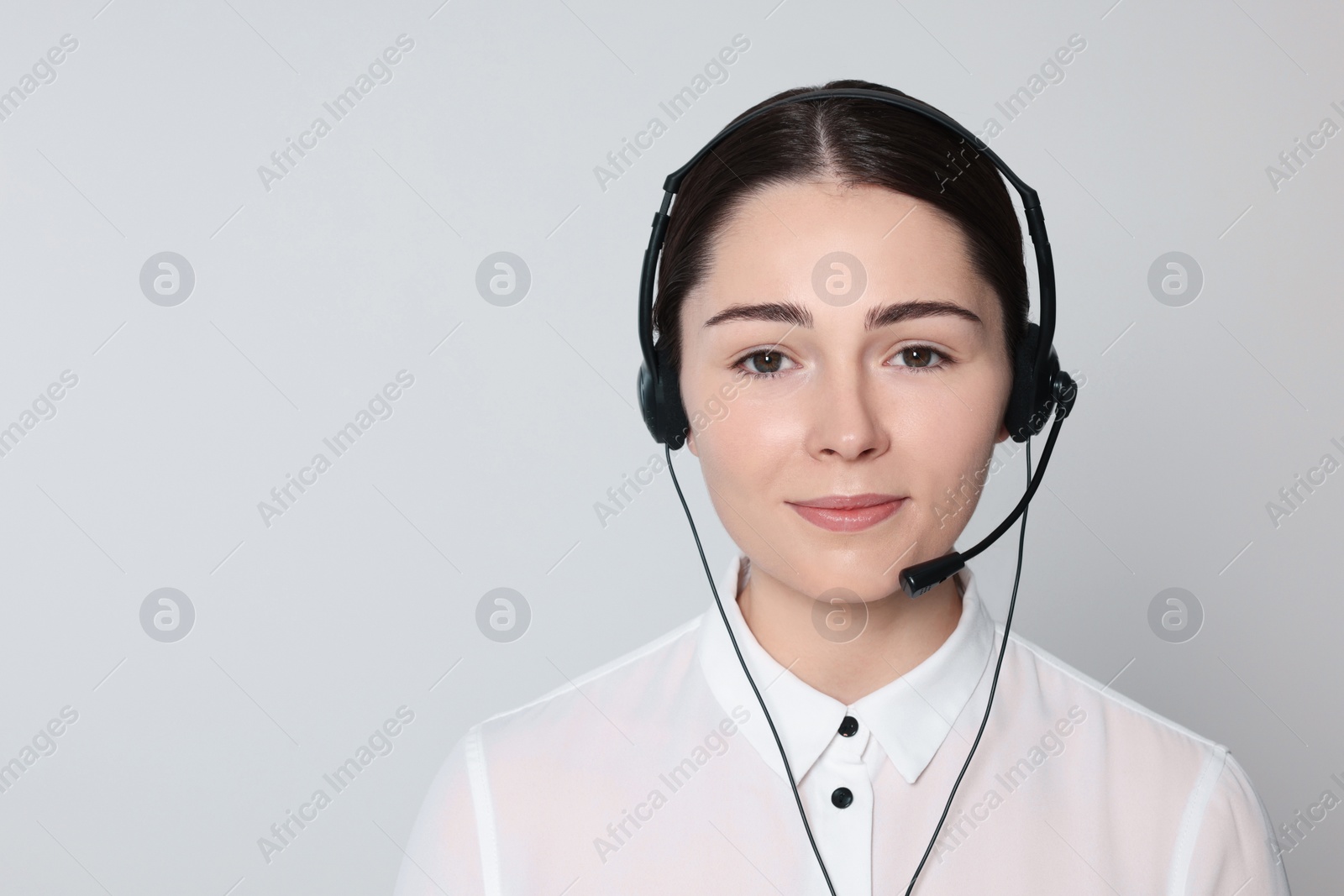 Photo of Hotline operator with modern headset on light grey background, space for text. Customer support