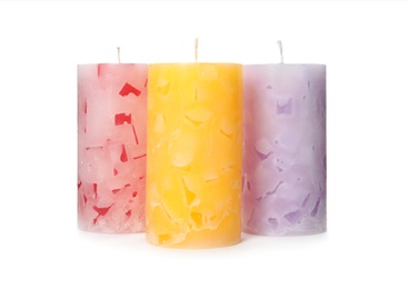 Three color wax candles on white background