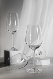 Photo of Empty wine glasses and cube on white wooden table