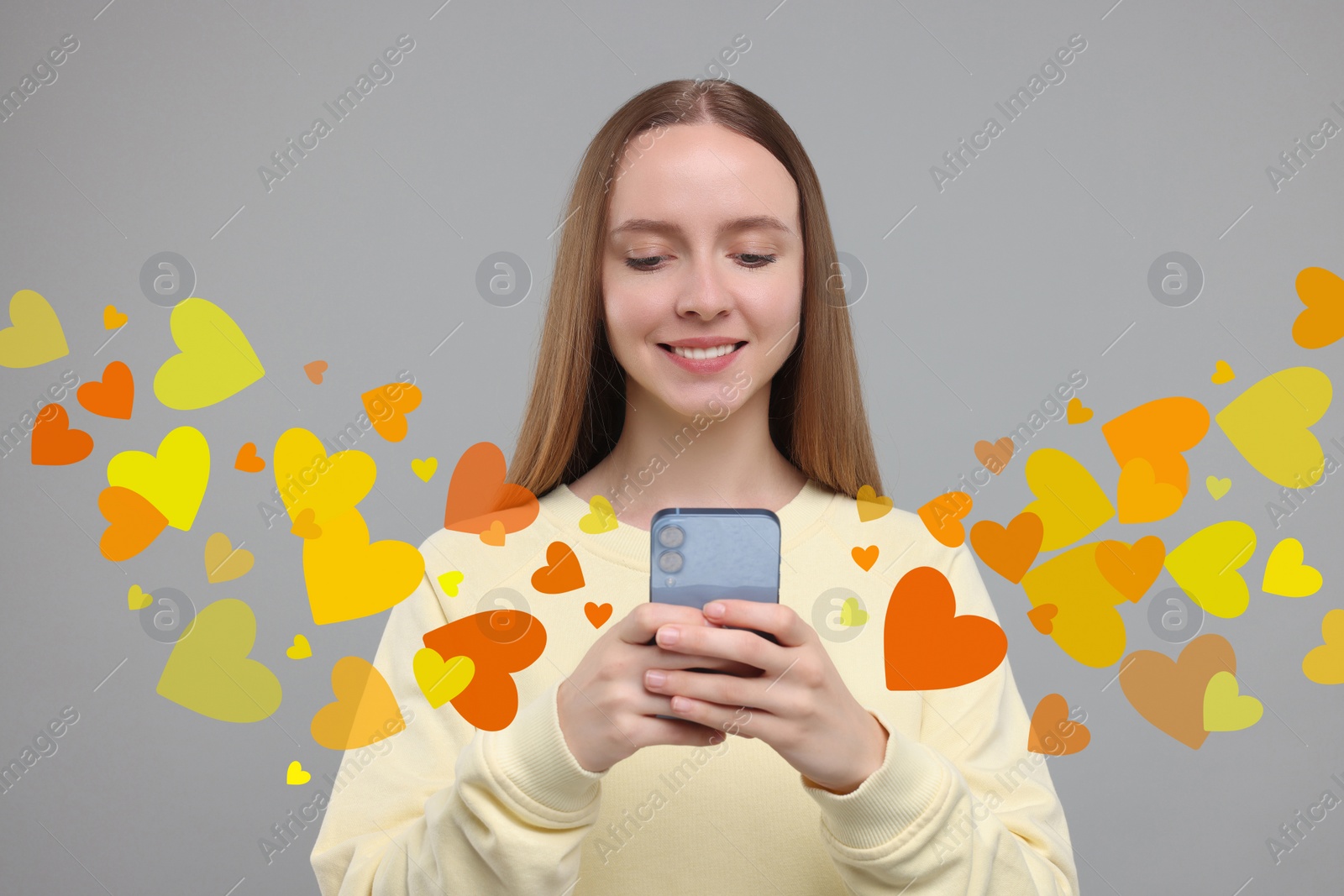 Image of Long distance love. Woman chatting with sweetheart via smartphone on grey background. Hearts flying out of device