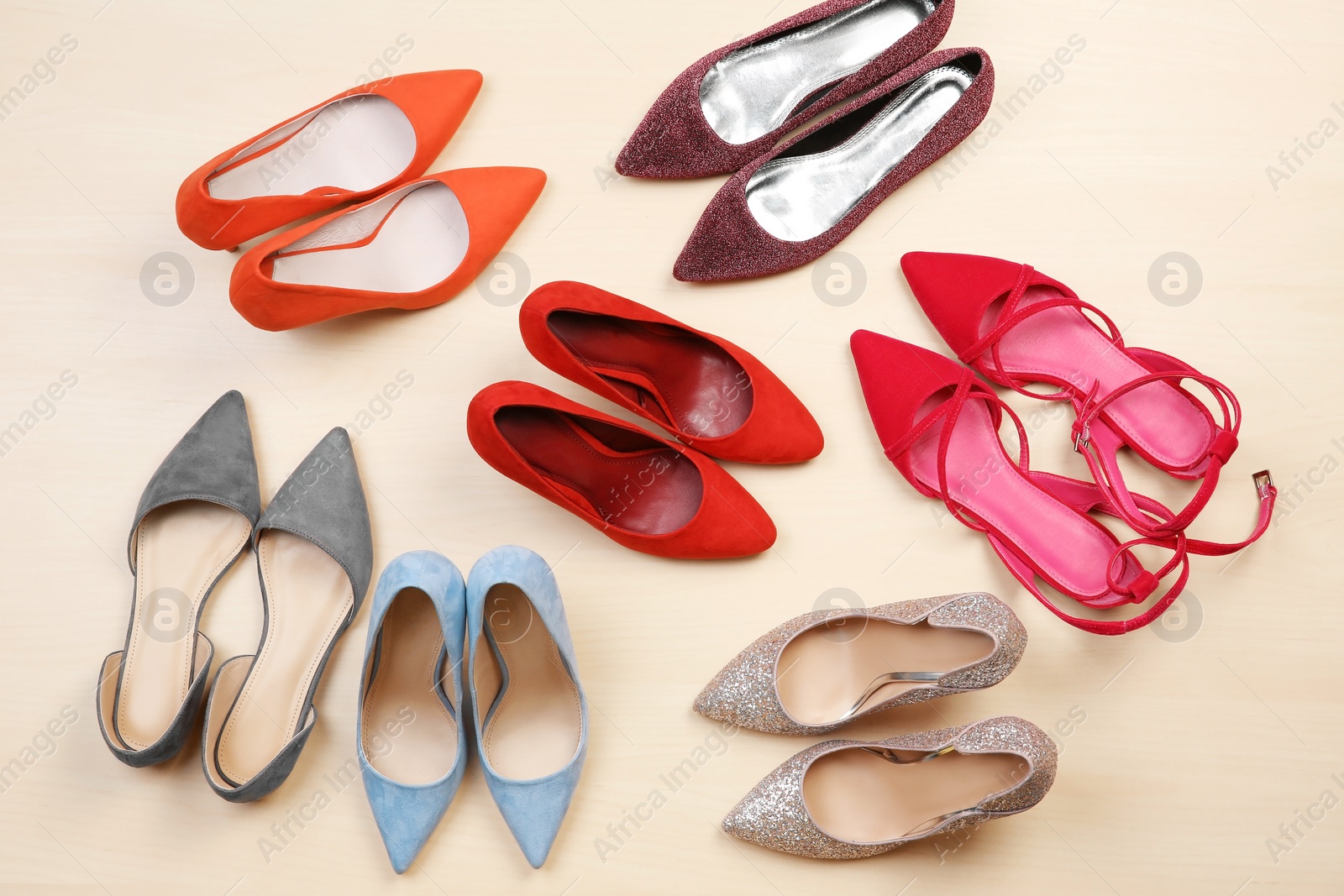 Photo of Different female shoes on wooden background