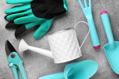Photo of Flat lay composition with watering can and gardening tools on light grey background