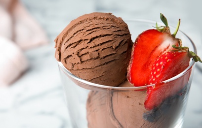 Photo of Glass of chocolate ice cream with strawberry on blurred background, closeup. Space for text