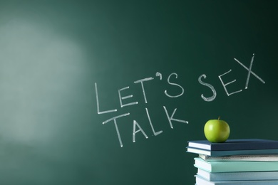 Photo of Books and apple near chalkboard with phrase "Let's talk sex"