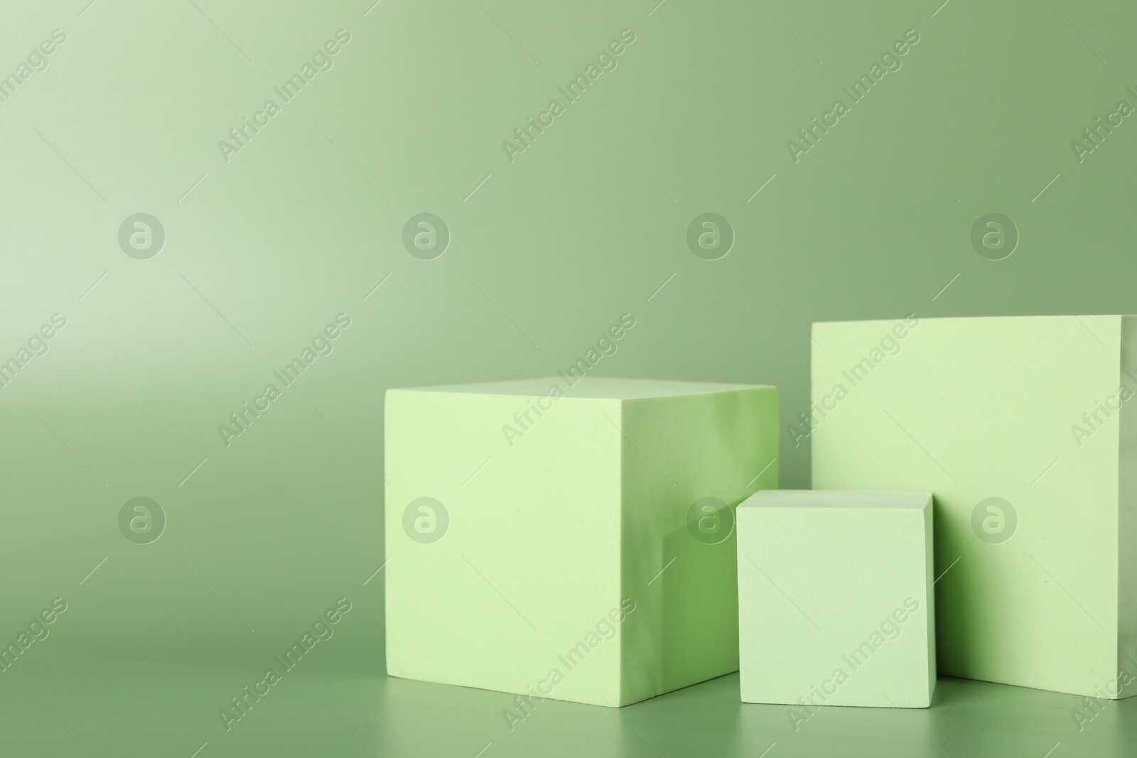 Photo of Presentation of product. Podiums and shadows on green background. Space for text