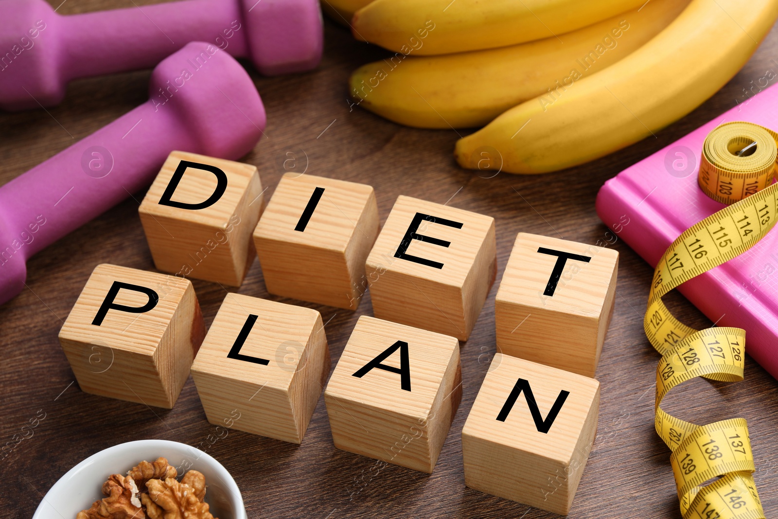 Photo of Phrase Diet Plan made of cubes, fitness items and products on wooden table. Weight loss concept