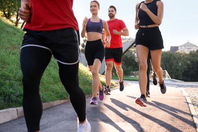 Photo of Group of people running outdoors on sunny day