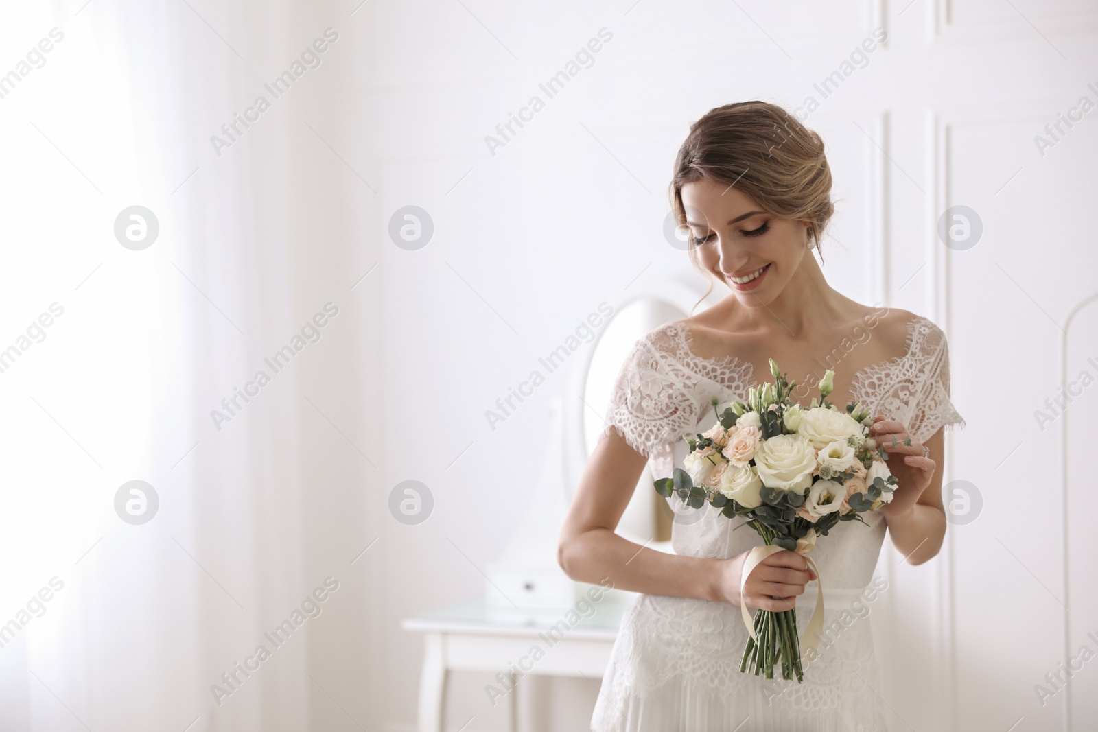 Photo of Bride in beautiful wedding dress with bouquet indoors. Space for text