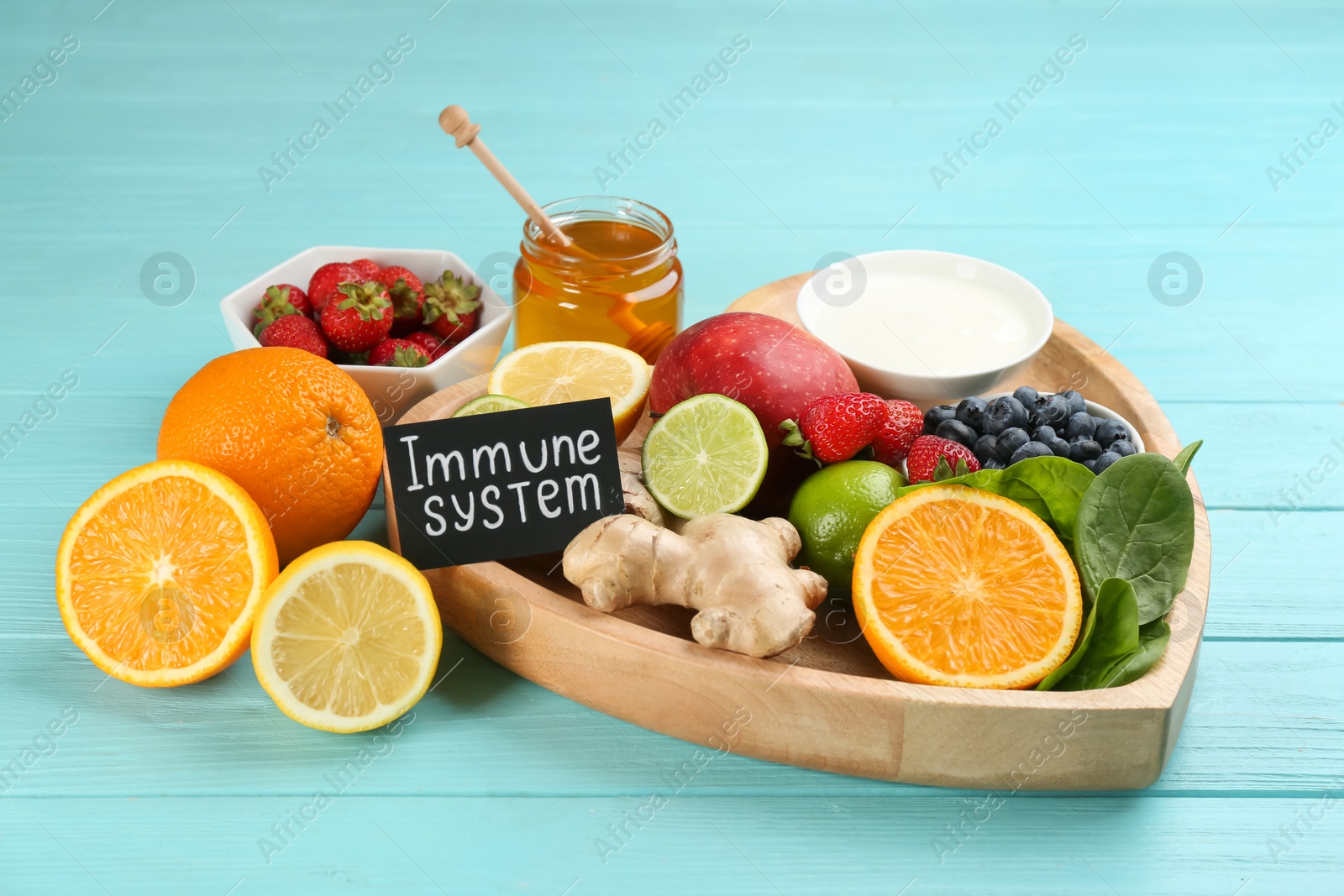 Photo of Card with phrase Immune System and fresh products on light blue wooden table