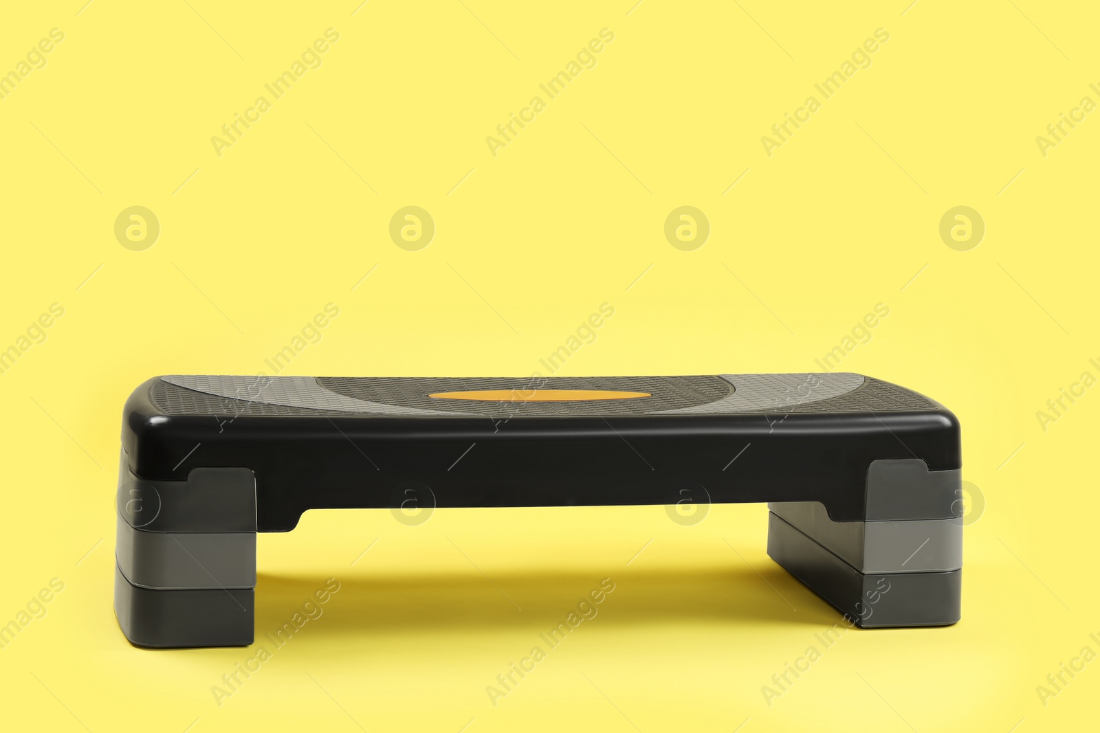 Photo of Step platform on yellow background, space for text. Sport equipment