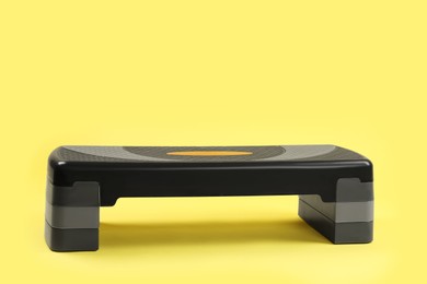 Step platform on yellow background, space for text. Sport equipment