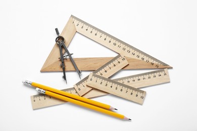 Different rulers and stationery on white background, top view