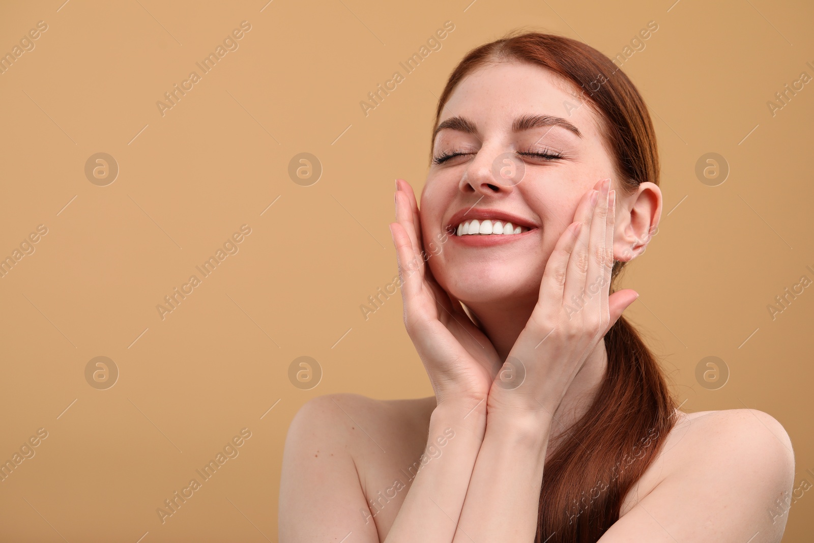 Photo of Portrait of smiling woman with freckles on beige background. Space for text
