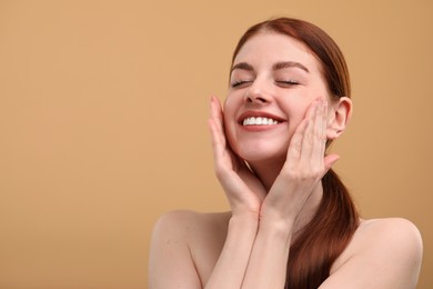 Portrait of smiling woman with freckles on beige background. Space for text