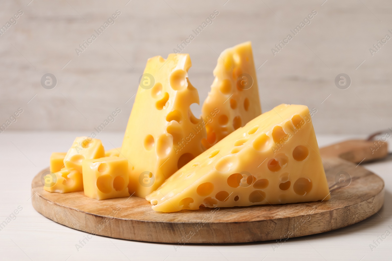 Photo of Pieces of delicious cheese on white wooden table