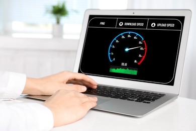 Image of Speed test. Woman using laptop at table, closeup