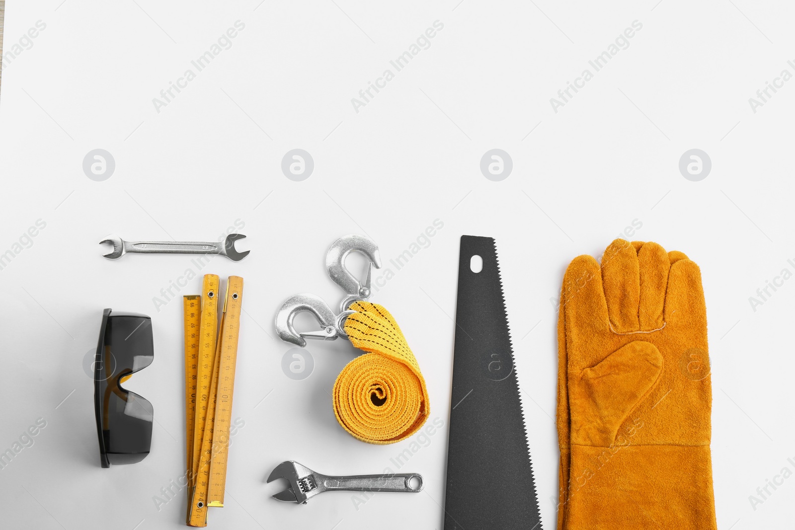 Photo of Flat lay composition with construction tools and safety equipment on white background. Space for text