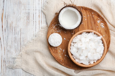 Photo of Composition with fresh coconut flakes in bowls on wooden background, top view