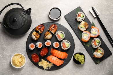 Flat lay composition with delicious sushi rolls on light grey table