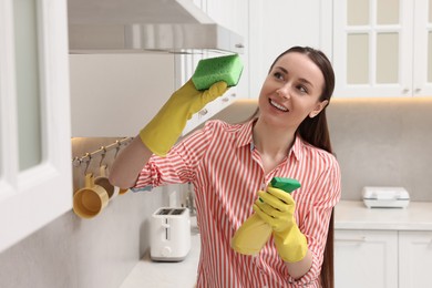 Photo of Spring cleaning. Young woman tidying up kitchen at home